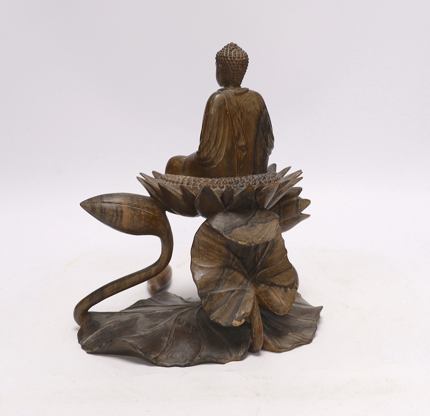 A Thai carved hardwood model of a Buddha on a lotus, damaged, loose piece, 22cm